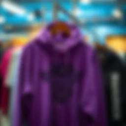 A stylish purple graphic hoodie displayed on a hanger, showcasing intricate designs.
